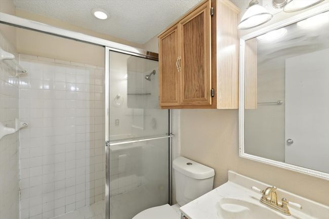Bathroom with a shower stall, vanity, and a textured ceiling | Image 10