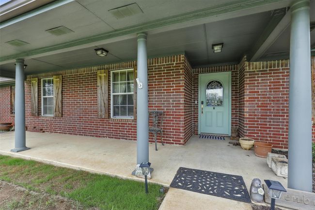 Entrance to property featuring brick siding and covered porch | Image 5