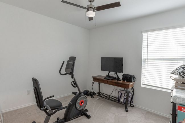 Exercise room featuring a wealth of natural light, carpet flooring, baseboards, and a ceiling fan | Image 13