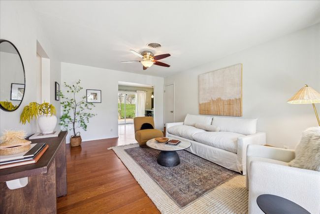 Living area with ceiling fan, visible vents, baseboards, and wood finished floors | Image 4