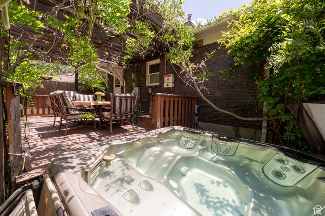 View of patio with a hot tub, a deck, and outdoor dining area | Image 25