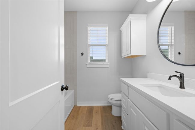 Bathroom featuring toilet, hardwood / wood-style floors, vanity, and a wealth of natural light | Image 27