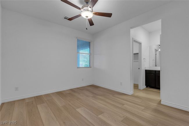 Empty room with light wood-style flooring, a ceiling fan, and baseboards | Image 10