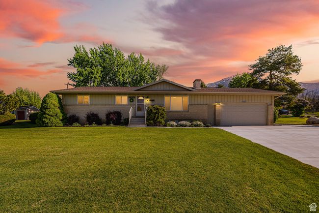 Ranch-style home with a chimney, brick siding, a front lawn, concrete driveway, and an attached garage | Image 42