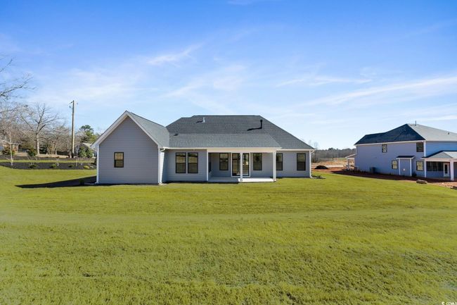 Rear view of house with a yard and a shingled roof | Image 38