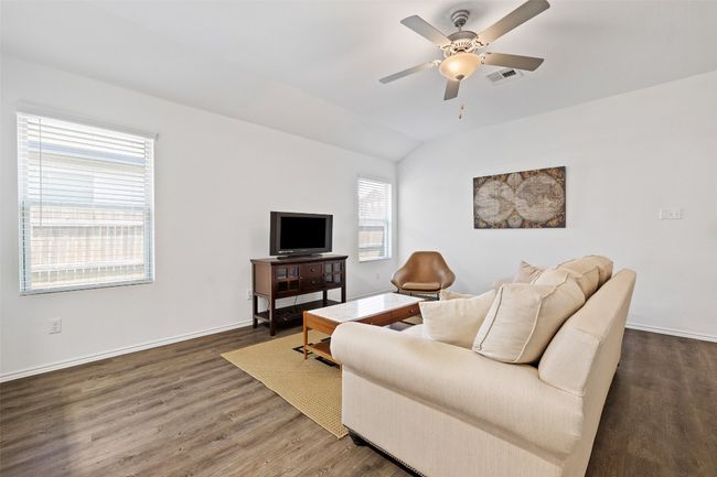 Living area featuring a ceiling fan, wood finished floors, and lofted ceiling | Image 7