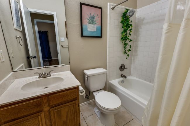 Full bath featuring tile patterned floors, shower / tub combo with curtain, toilet, and vanity | Image 17
