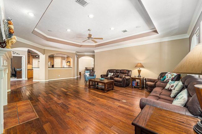 This spacious living room seamlessly flows into the kitchen. | Image 12