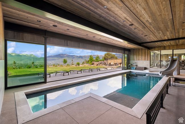 Swimming pool with a water slide and a mountain view | Image 63