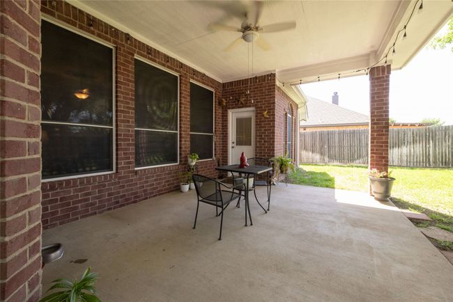 View of patio with a fenced backyard and a ceiling fan | Image 36