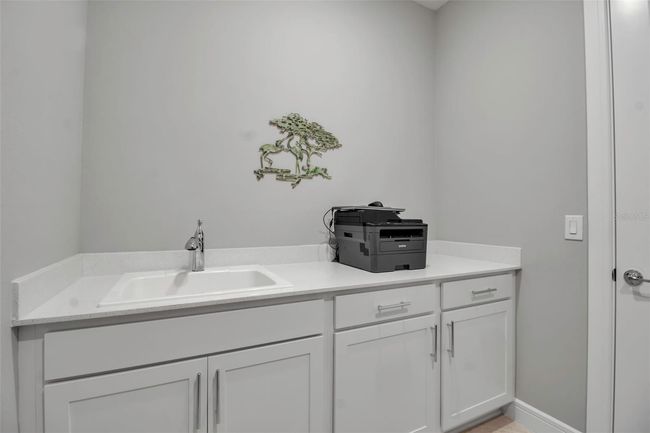 Laundry room has lower cabinets and wash sink | Image 56