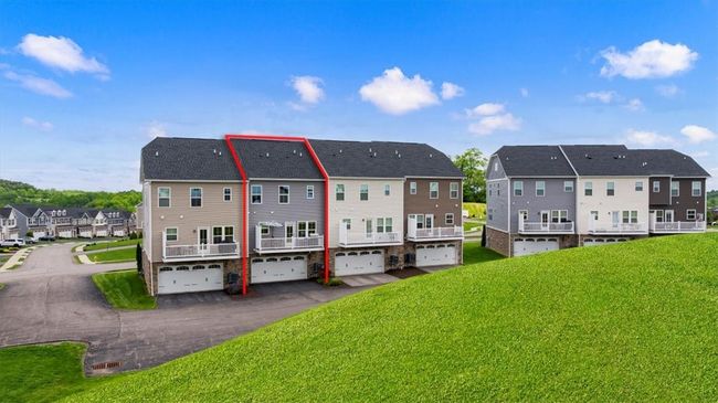 This modern townhome community features stylish, three-story residences with attractive exterior finishes and private rear decks. Each unit offers attached garages and driveway parking, providing both convenience and curb appeal. Set against a backdrop of lush green space and open skies, the neighborhood boasts a peaceful suburban setting while maintaining easy access to nearby amenities. Ideal for those seeking low-maintenance living with contemporary design in a vibrant, connected community. | Image 21