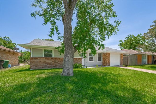 This shot captures the lush front lawn, including a mature tree that offers charm and shade. | Image 34