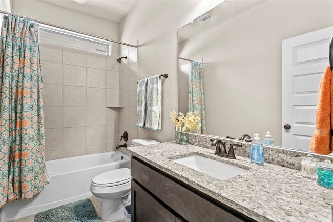 Bathroom with vanity, shower / tub combo with curtain, and tile patterned floors | Image 22