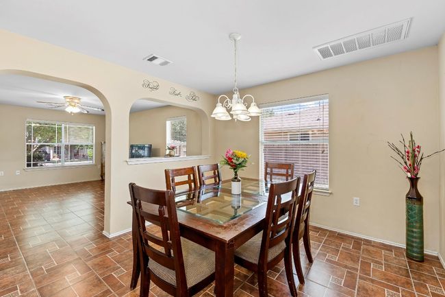 Dining area with a chandelier, arched walkways, and a ceiling fan | Image 13