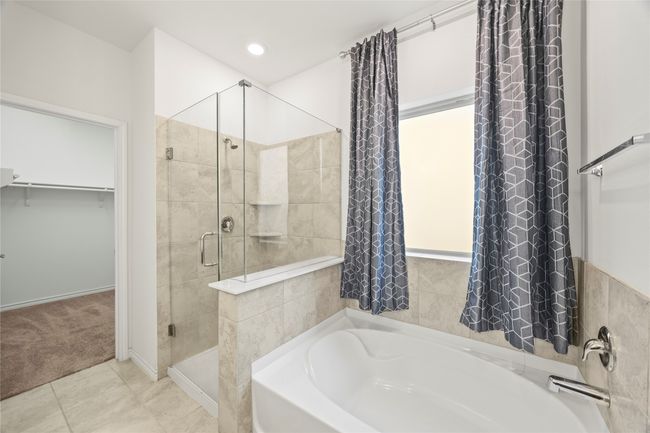 Full bath featuring a stall shower, a bath, and a spacious closet | Image 25