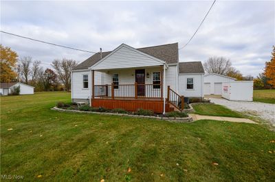 Bungalow-style home featuring a covered front porch and 4+car garage | Image 1