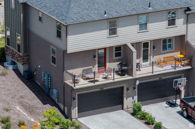 Back of house featuring an attached garage, roof with shingles, driveway, and stucco siding | Image 38