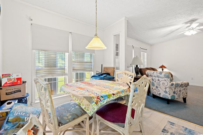 Dining area featuring ornamental molding, ceiling fan, and a textured ceiling | Image 6