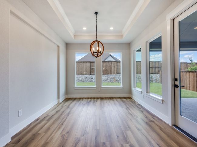 Filled with light from walls of windows, this dream dining room is the perfect place to host grand dinner parties or cozy family meals! | Image 11