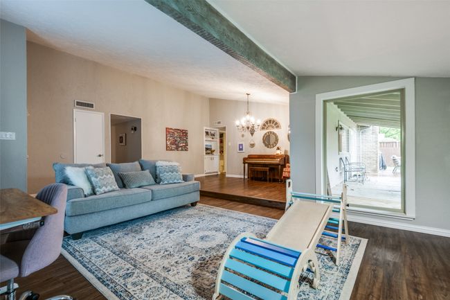 Living area with a chandelier, visible vents, vaulted ceiling, and wood finished floors | Image 21