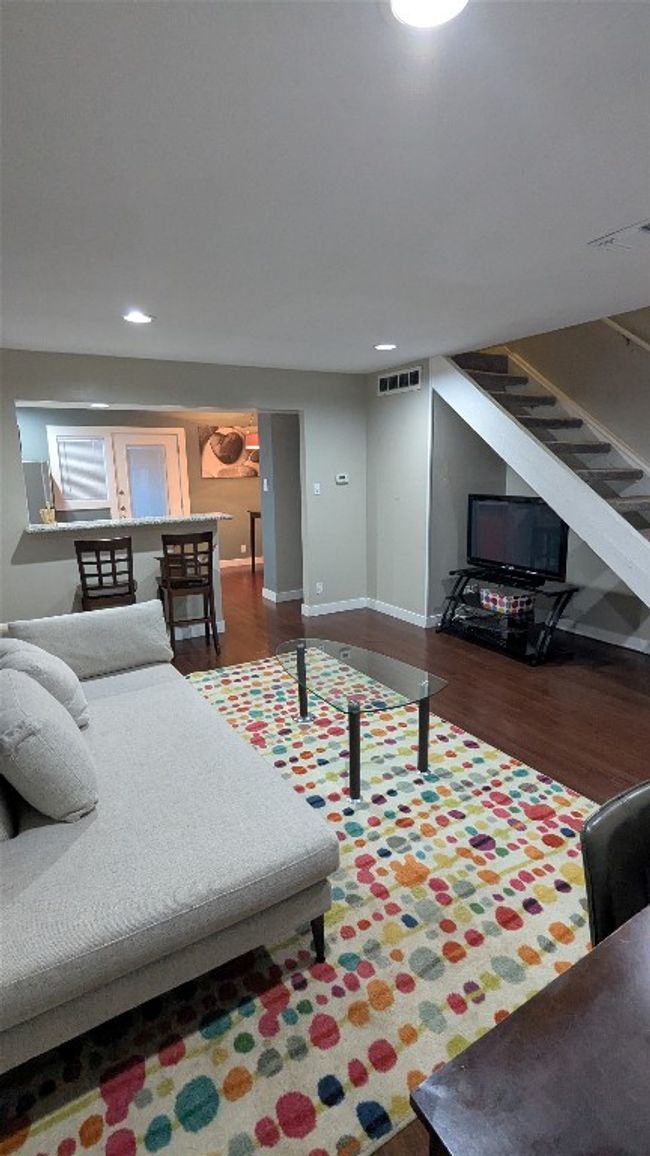 Living area with recessed lighting, wood finished floors, stairs, and baseboards | Image 7