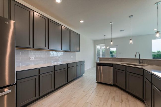 Kitchen featuring appliances with stainless steel finishes, backsplash, plenty of natural light, recessed lighting, and light countertops | Image 11