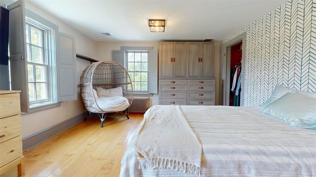 Bedroom with multiple windows, radiator heating unit, and light hardwood / wood-style flooring | Image 28