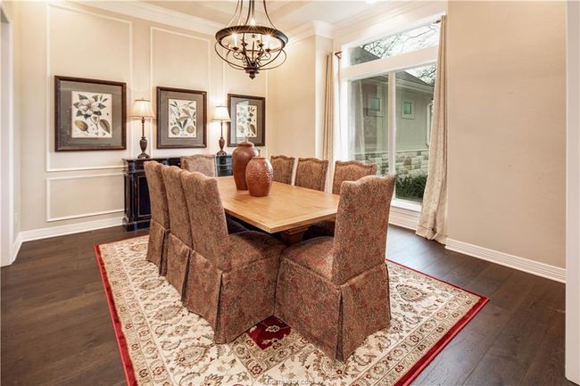 Dining area with crown molding, dark wood-style flooring, baseboards, and a notable chandelier | Image 15