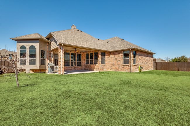 Back of house featuring brick siding, a shingled roof, fence, a patio area, and a ceiling fan | Image 37