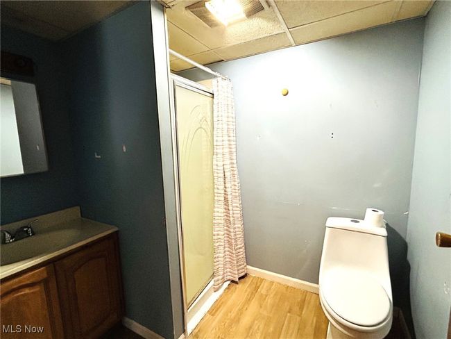 Full bathroom featuring wood finished floors, vanity, a stall shower, and toilet | Image 13
