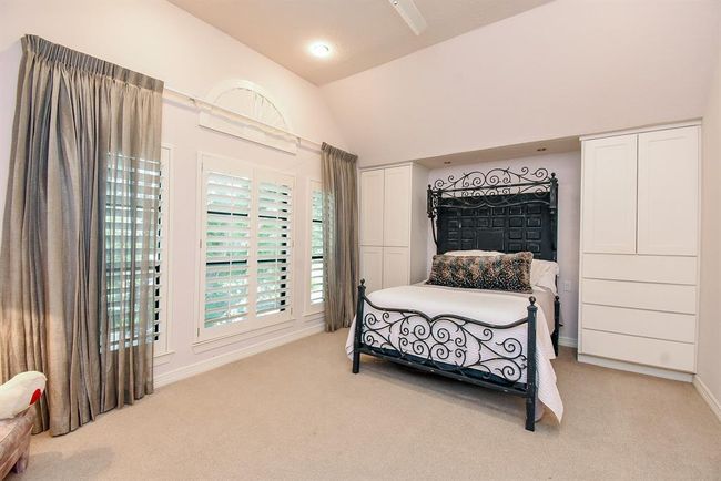 This 4th large secondary bedroom features a bank of windows and built in closet and drawers flanking the bed. x | Image 39