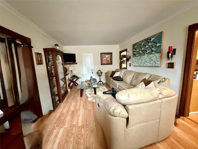 Living area featuring light wood-type flooring and crown molding | Image 5