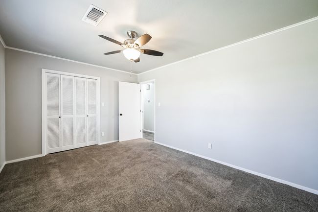 Unfurnished bedroom featuring visible vents, baseboards, a closet, and crown molding | Image 15