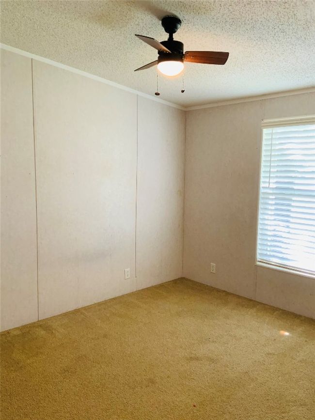 Carpeted spare room with a textured ceiling, a ceiling fan, and ornamental molding | Image 25