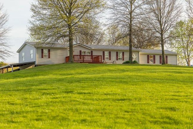 Back of house featuring metal roof, a lawn, and a deck | Image 68