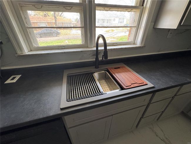 Kitchen featuring marble finish floor, dark countertops, and a sink | Image 8