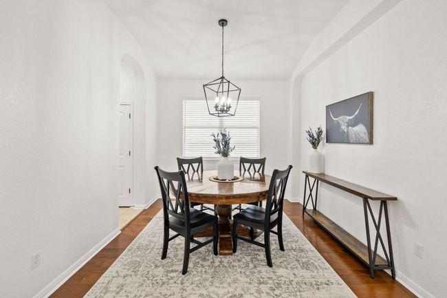 Dining room featuring a chandelier, arched walkways, and dark wood-type flooring | Image 9