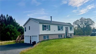 Bi-level home featuring a garage and a front lawn | Image 2