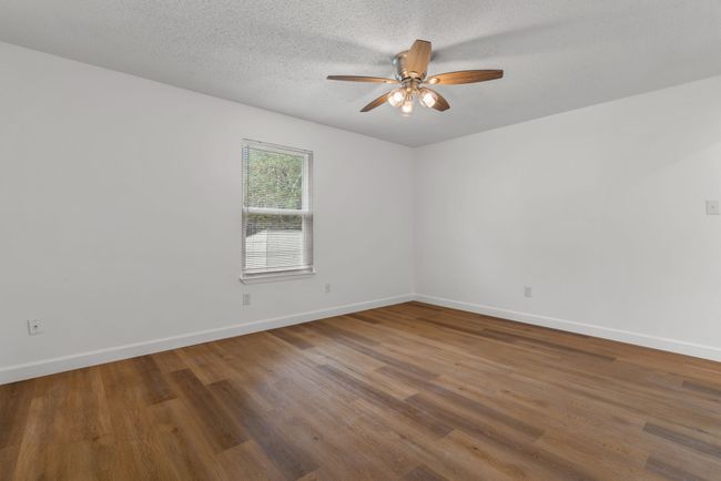Unfurnished room with ceiling fan, wood finished floors, and a textured ceiling | Image 20