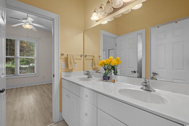 Full bath with double vanity, ceiling fan, and wood finished floors | Image 26