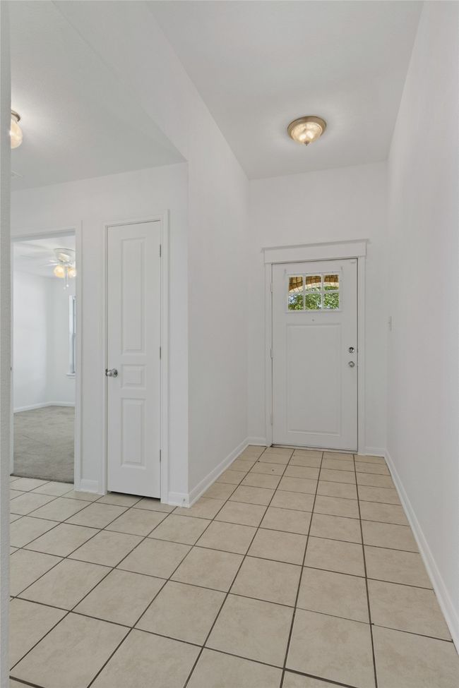 Hall with baseboards and light tile patterned floors | Image 5