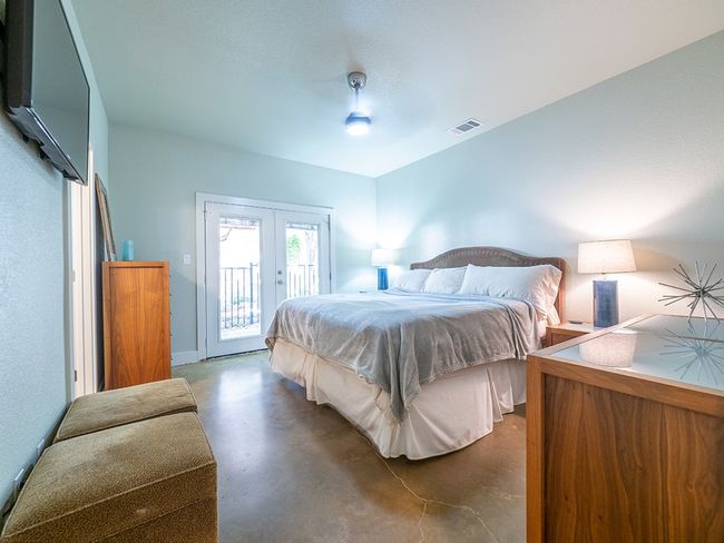 Bedroom with concrete flooring, access to outside, french doors, and a ceiling fan | Image 14