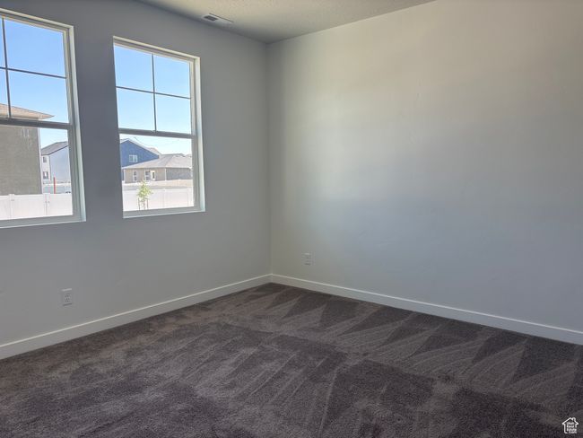 Unfurnished room featuring plenty of natural light and dark colored carpet | Image 4