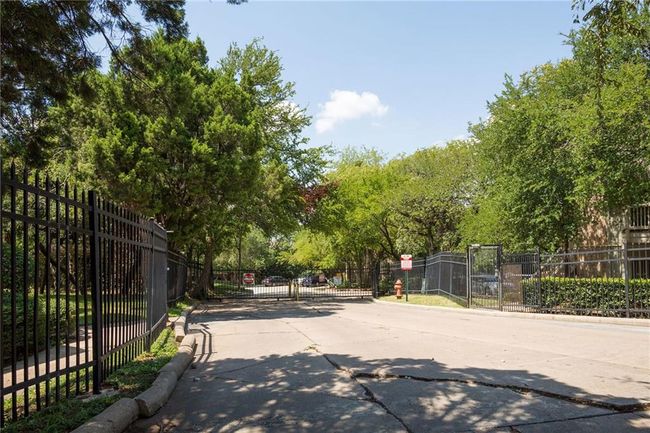 View of concrete street with a gate, curbs, and a gated entry | Image 28