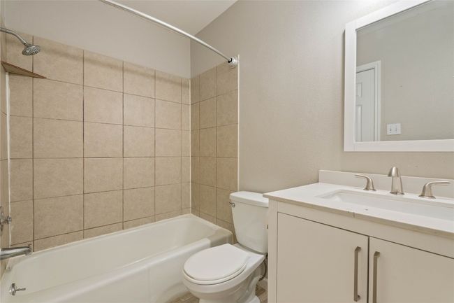 Freshly updated full bathroom with sleek brushed nickel fixtures, a modern white vanity, and neutral tiled shower — clean, bright, and ready to go! | Image 13