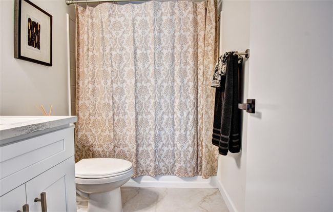 Full bath with marble finish floor, toilet, vanity, and shower / tub combo | Image 17