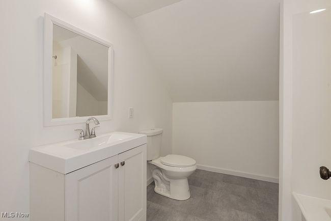 Bathroom featuring vaulted ceiling, toilet, tile patterned flooring, and vanity | Image 37