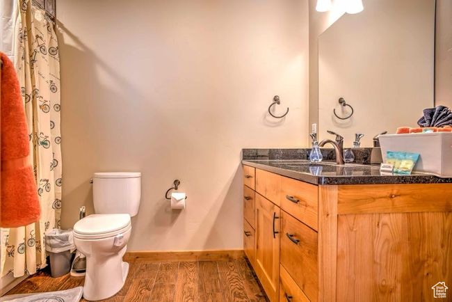 Full bath with wood finished floors, vanity, toilet, and baseboards | Image 16
