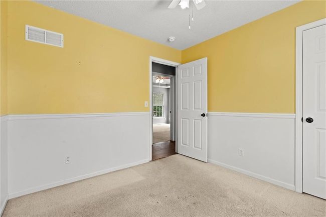 Unfurnished bedroom with carpet, ceiling fan, and a textured ceiling | Image 27